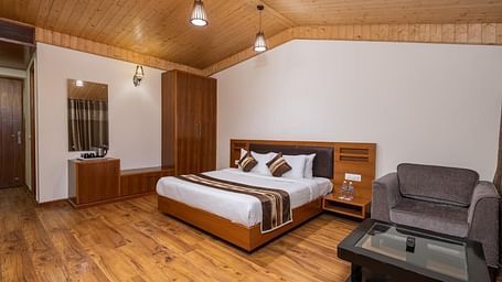 Image of a room with king size bed, side table and a cupboard